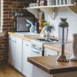 Immersion blender on a kitchen counter in a beautiful rustic kitchen with lots of light coming through the windows